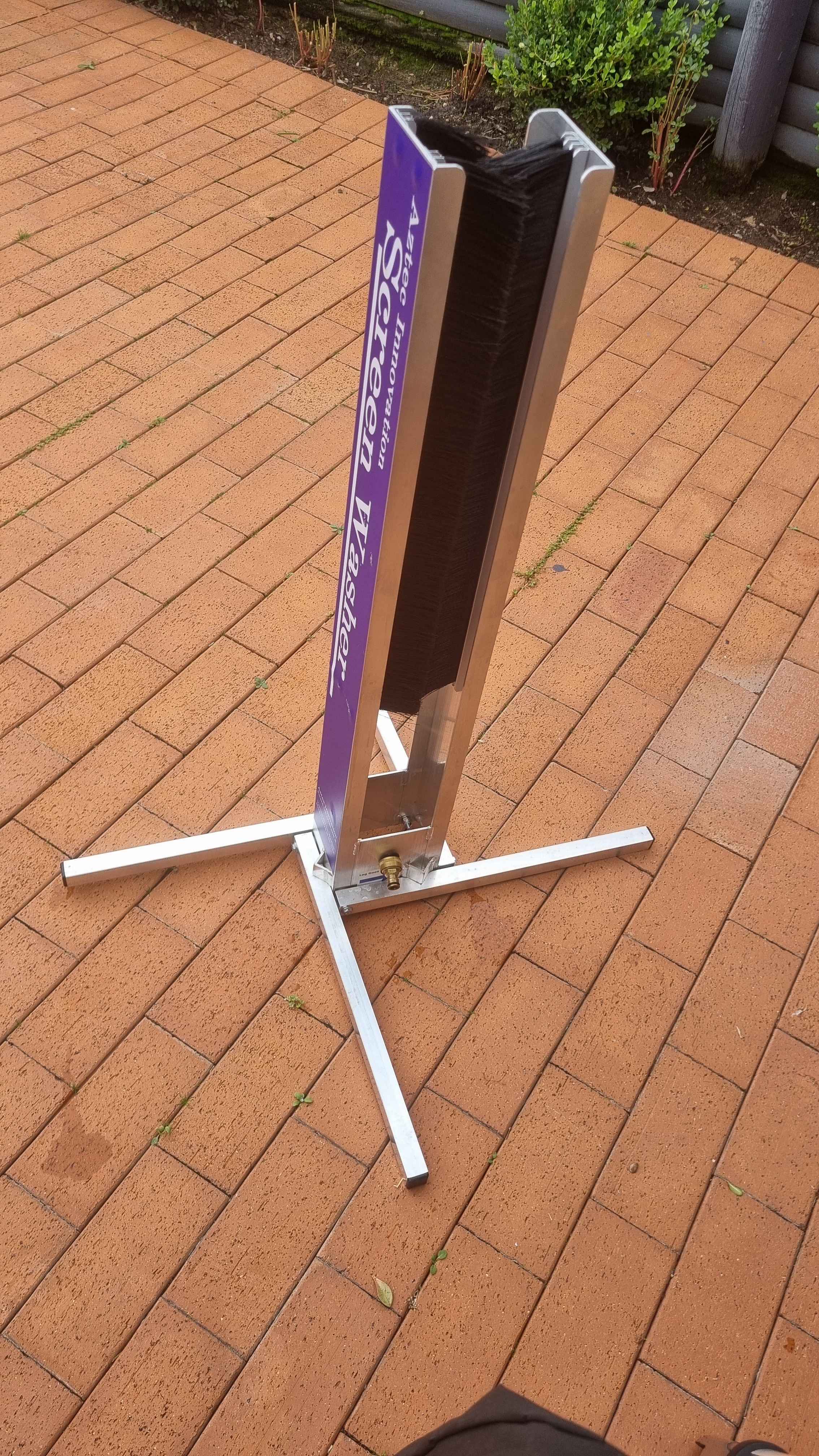 Aztec Innovation Screen Washer with black brushes and a purple panel on a brick patio.